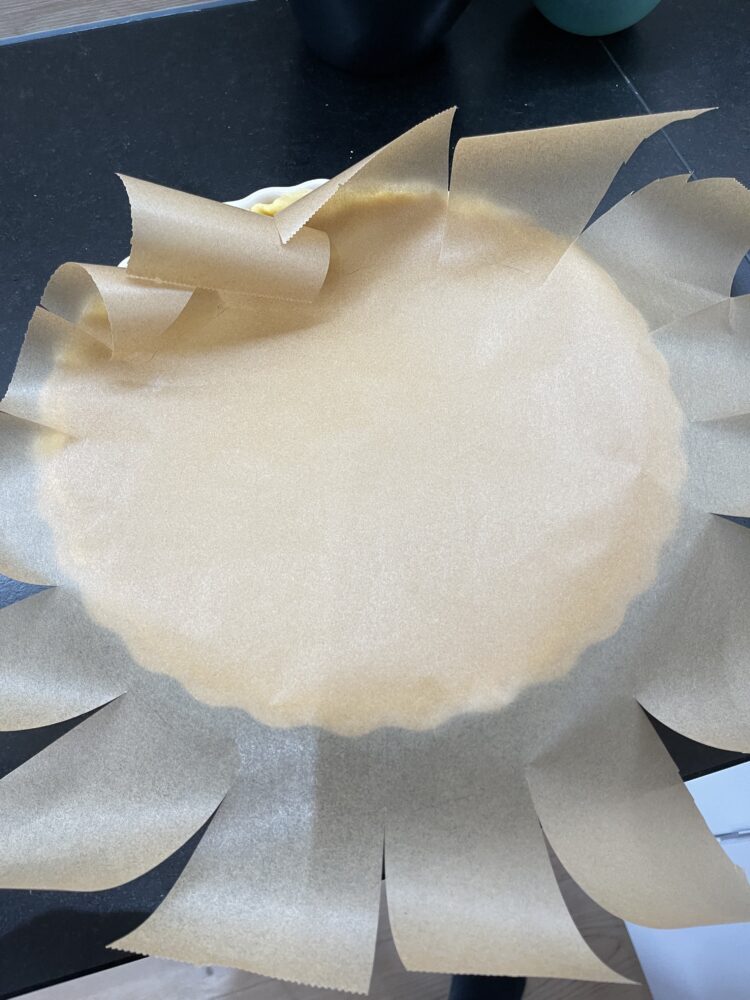 Vorbereitung zum Blindbacken einer Tarte: Backpapier wird zugeschnitten